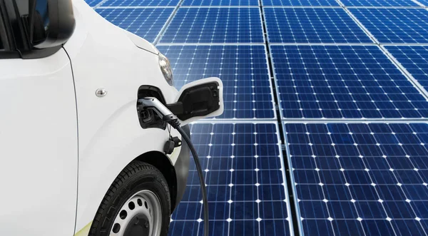 Güneş Panelinin Arka Planında Şarj Istasyonu Olan Elektrikli Bir Minibüs — Stok fotoğraf