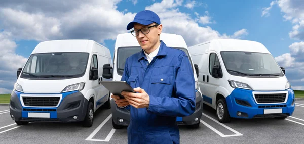 Manager with a digital tablet on the background of vans. Fleet management.