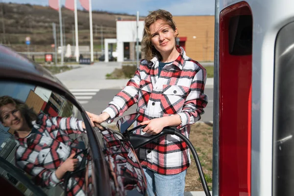 Vrouw Een Geruit Shirt Die Een Elektrische Auto Oplaadt Hoge — Stockfoto