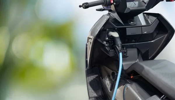 Elektrische Scooter Met Aangesloten Oplaadkabel Een Groene Achtergrond Hoge Kwaliteit — Stockfoto