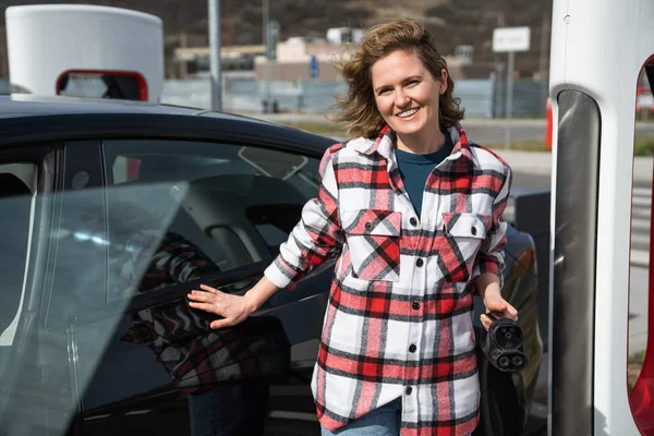Vrouw Een Geruit Shirt Die Een Elektrische Auto Oplaadt Hoge — Stockfoto
