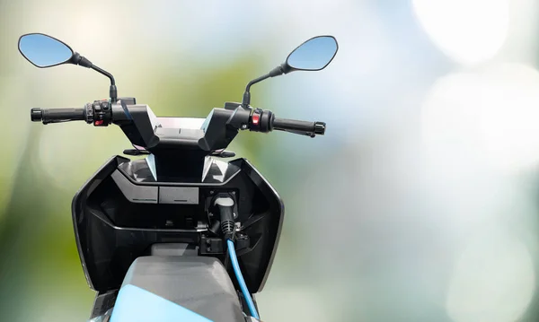 Elektrische Scooter Met Aangesloten Oplaadkabel Een Groene Achtergrond Hoge Kwaliteit — Stockfoto