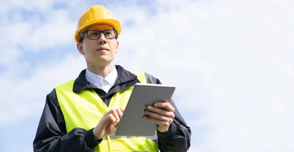 Engineer with digital tablet on a background of blue sky. High quality photo
