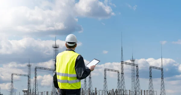 stock image Worker with digital tablet on a background of power station. High quality photo