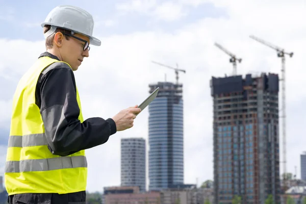 stock image Engineer with a digital tablet on the background of a building under construction. High quality photo