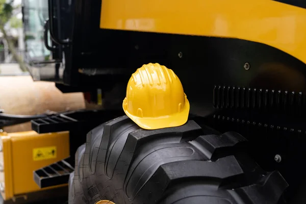 Yellow Hard Hat Lies Wheel Construction Machine High Quality Photo — Stock Photo, Image