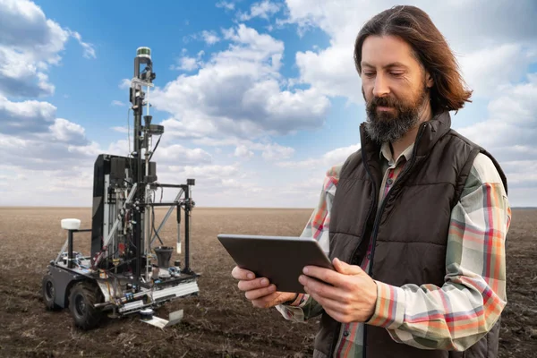Mezőgazdasági Termelő Ellenőrzi Autonóm Robotot Talaj Minőségének Mérésére Egy Mezőgazdasági — Stock Fotó