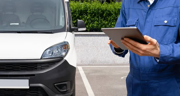 Manager with a digital tablet on the background of delivery van. Fleet management. High quality photo