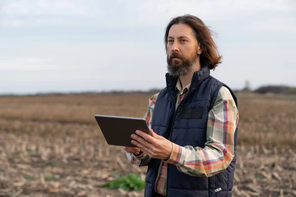 Farmer with digital tablet on an agricultural field. Smart farming and digital agriculture. High quality photo