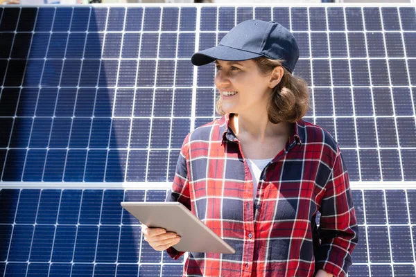 stock image Woman with digital tablet on a background of mobile solar power station