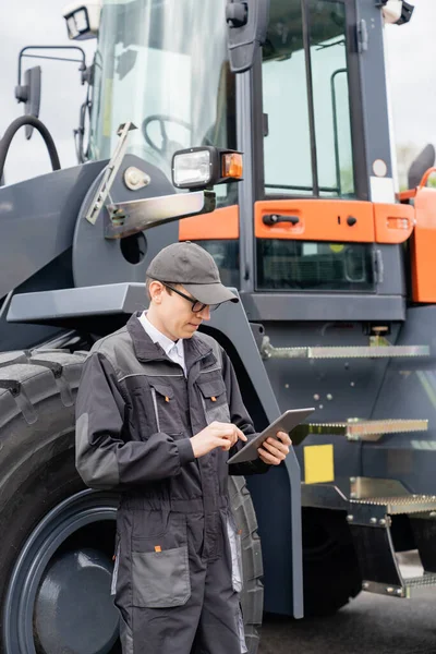 Muž Digitálním Tabletem Vedle Průmyslového Traktoru — Stock fotografie