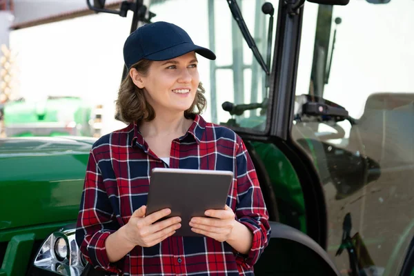 Vrouwelijke Boer Met Een Digitale Tablet Achtergrond Van Een Landbouwtrekker — Stockfoto
