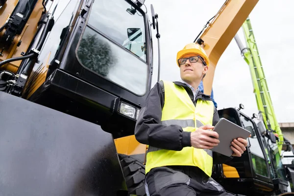 Engenheiro Capacete Com Tablet Digital Fica Lado Escavadeiras Construção — Fotografia de Stock