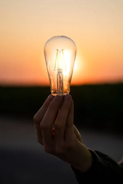 Primer Plano Lámpara Eléctrica Mano Backgoriun Una Puesta Sol Símbolo — Foto de Stock