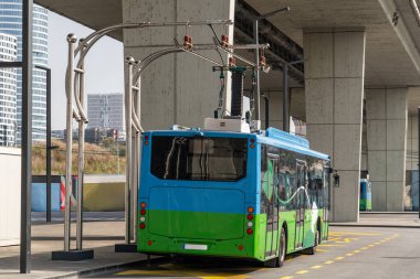 Electric bus at a stop is charged by pantograph. Clean mobility. clipart