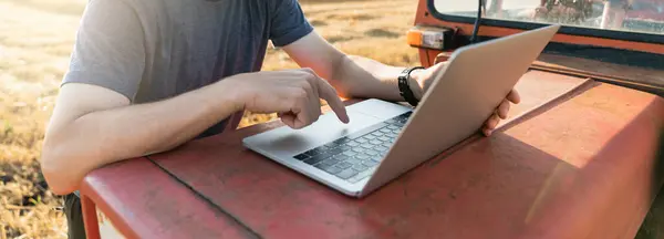 Rolnik Pracuje Laptopie Obok Ciągnika Rolniczego — Zdjęcie stockowe