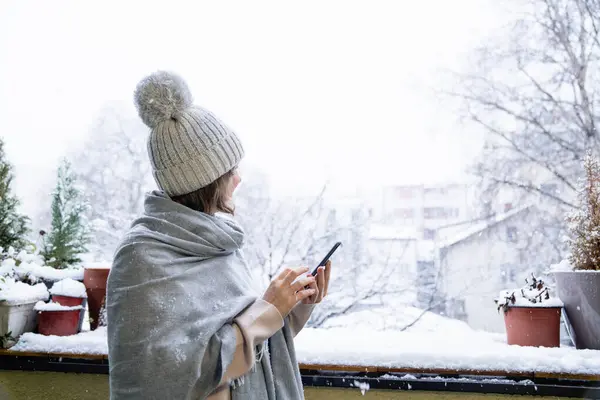 Een Vrouw Met Een Warme Hoed Deken Houdt Een Smartphone — Stockfoto