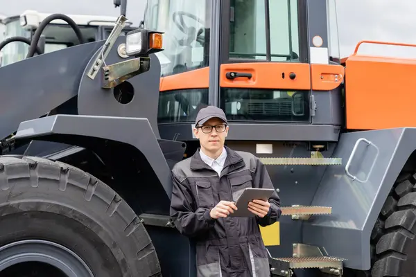 Serviceman Med Digital Tablett Bakgrund Traktorn — Stockfoto