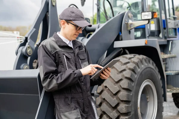 Serviceman Com Tablet Digital Fundo Trator — Fotografia de Stock