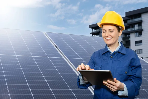 太陽電池パネルの背景にタブレットコンピュータを搭載した女性エンジニア — ストック写真