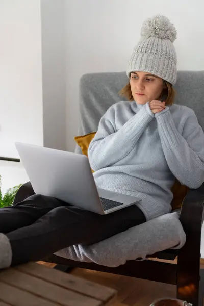 一个穿着保暖衣服 带着笔记本电脑的女人 房子的温度很低 能源危机概念 — 图库照片
