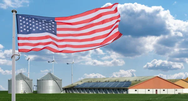 American flag on a background of modern farm using renewable energy.