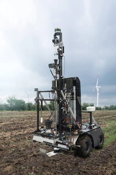 Autonomiczny Robot Pomiaru Jakości Gleby Polu Rolniczym Turbina Wiatrowa Horyzoncie — Zdjęcie stockowe