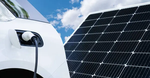 電気自動車は ソーラーパネルからエネルギーを取る充電ステーションから充電されます — ストック写真