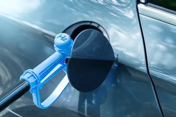 Close up of fuel cell car with connected hydrogen fueling nozzle