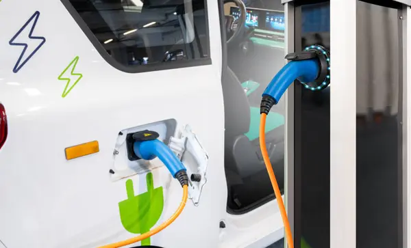 Close up of electric car inlet with a connected charging cable.