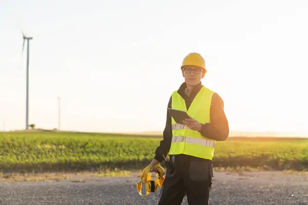 Stock image Engineer with digital tablet controls wind turbines.