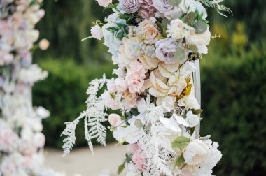 Açık hava töreninde düğün kemerindeki çiçeklerin yakın görüntüsü.