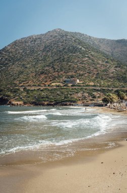 Yunanistan 'ın güzel romantik kenti Bali' deki plajın kıyısından harika bir manzara. Limani sahil limanı ve binalar. Arka planda mavi gökyüzünün altındaki dağlar var..