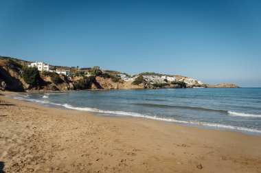 Yunanistan 'ın güzel romantik kenti Bali' deki plajın kıyısından harika bir manzara. Limani sahil limanı ve binalar. Arka planda mavi gökyüzünün altındaki dağlar var..