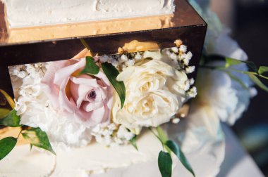 Üç katlı büyük kare düğün pastası. Kurşunlu ışığın arka planına karşı. Ukrayna 'da birinci sınıf düğün. Akşam lambalarının altında düğün tatlısı. Düğün dekoru.