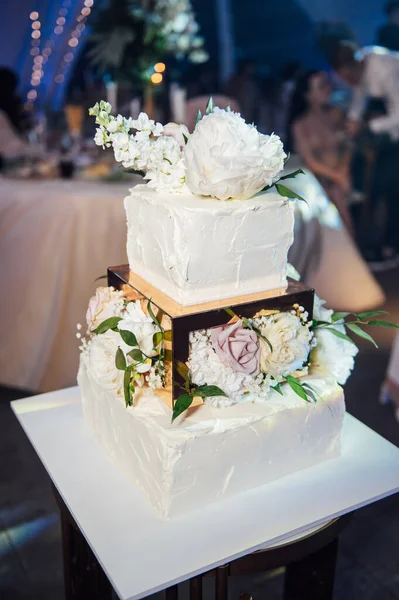 有三层的正方形婚礼蛋糕 在引导照明的背景下 在乌克兰举行的高级婚礼在夜光灯泡的照耀下 婚礼甜点 婚礼装饰 — 图库照片