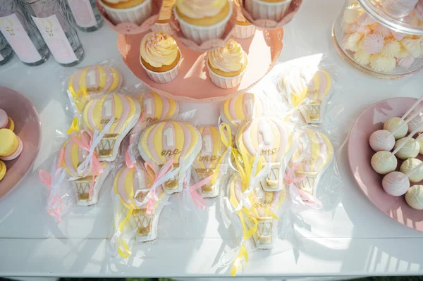 婴儿生日 蛋糕架上的法式马卡龙 有马卡龙 芝士蛋糕 蛋糕爆米花的糖果吧 托盘上的色彩斑斓的马卡龙 色彩艳丽的金黄色装饰的甜生日餐桌 — 图库照片
