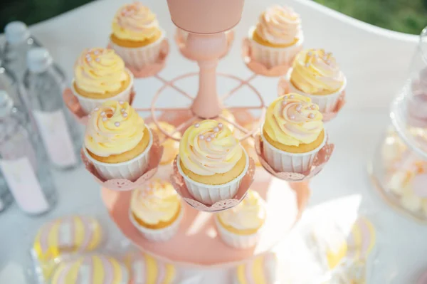 婴儿生日 蛋糕架上的法式马卡龙 有马卡龙 芝士蛋糕 蛋糕爆米花的糖果吧 托盘上的色彩斑斓的马卡龙 色彩艳丽的金黄色装饰的甜生日餐桌 — 图库照片