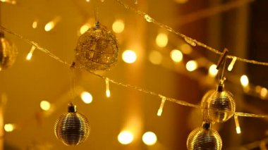 A cozy warm garland and round balls are hung on a homemade Christmas installation for the new year.