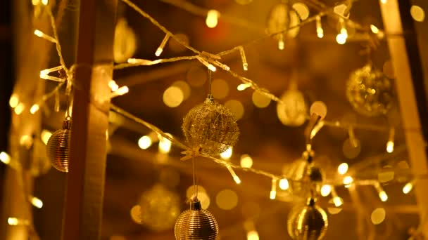 居心地の良い暖かいガーランドと丸いボールは 新年のための手作りのクリスマスのインストールに掛けられています — ストック動画