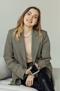 Woman psychologist sits on the couch and communicates in social networks with her clients.