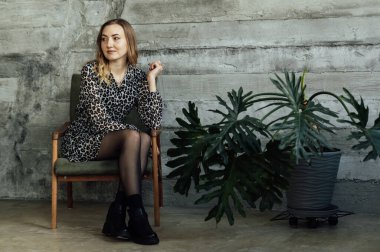 Beautiful female psychologist sits on a chair and waits for a client.