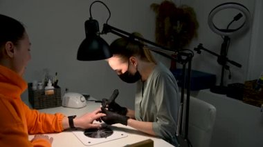 Çivi ustası kesiciyle çivinin önceki jelini çıkarıyor. Profesyonel bir iş için zor.