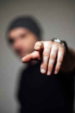 Siyahi stüdyonun arka planında dikilirken ciddi bir dramatik adam başka tarafa bakıyor..