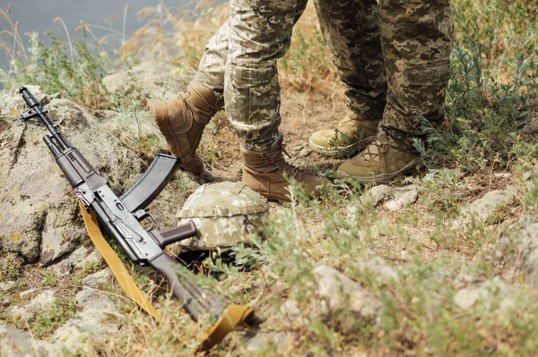 自動武器の隣に男と女の足 ウクライナ軍 ウクライナ兵 軍事制服 ストックフォト
