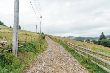Yürüyen insanlar ve off-road arabaları için dağlardaki eski kayalık toprak yol.
