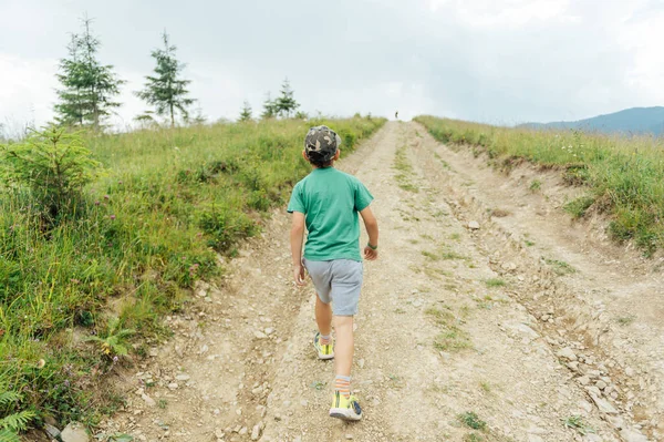 stock image The Ukrainian boy goes up the mountain road forward. Motivating photo.