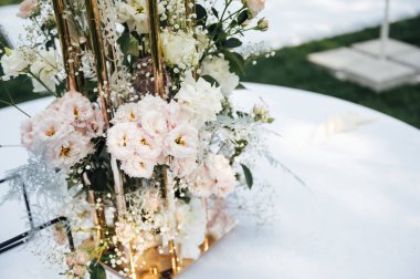 Düğün için. Ziyafet. Sandalyeler ve yuvarlak masa misafirler için çatal bıçak takımı, yeşillik çiçekleri ve çanak çömlek ile servis ediliyor ve beyaz bir masa örtüsüyle kaplanıyor. zeytin rengi