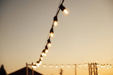 Düğün partisinde dekoratif lambalar. Akşam batımı.