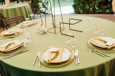 Açık hava düğün restoranı. Taze çiçekler ve özel yemeklerle süslenmiş. Çiçekli ve lambalı konuklar için masalar.